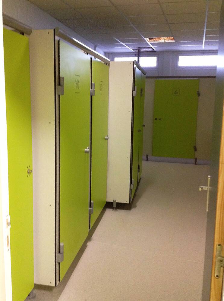 Cabines sanitaires vertes en panneaux compacts dans école