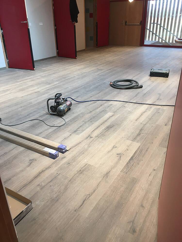 Pose de sol stratifié effet chêne dans un bâtiment