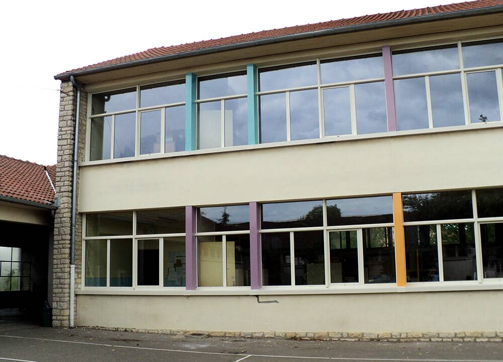Façade d'école avec menuiseries extérieures rénovées et colorées