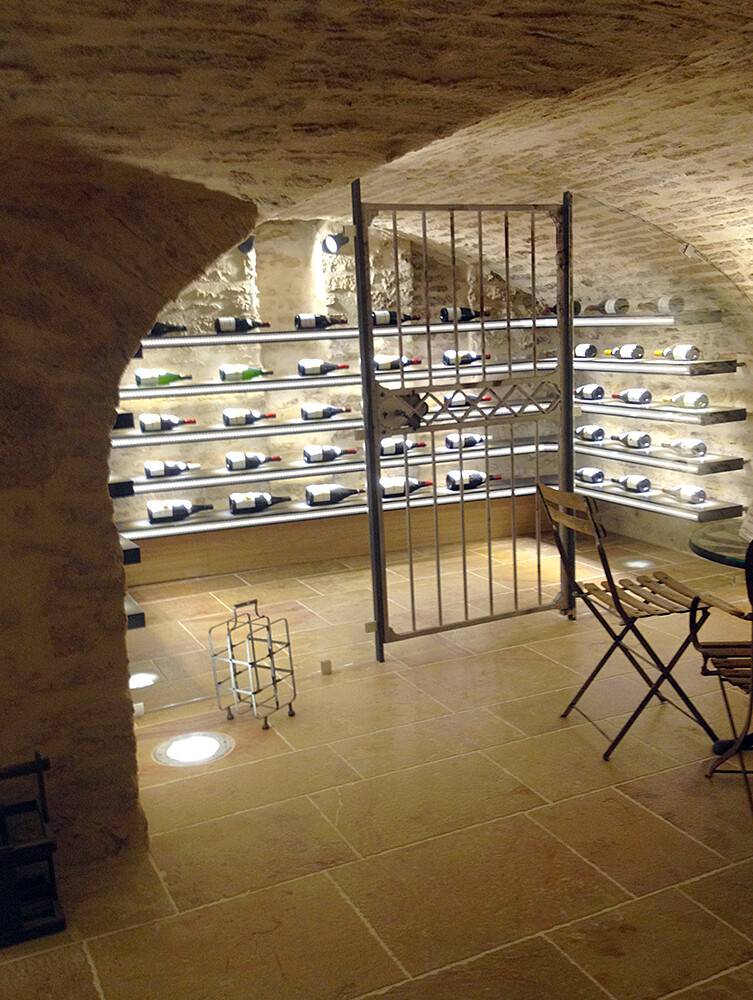 Cave à vin voûtée avec casiers rétro-éclairés et grille forgée