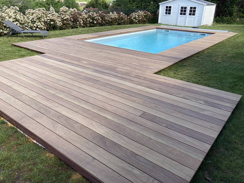 Plage de piscine en bois ipé patiné dans un jardin