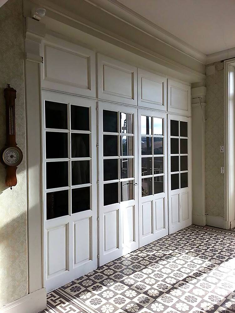 Menuiseries anciennes restaurées à petits-bois sur carreaux ciment