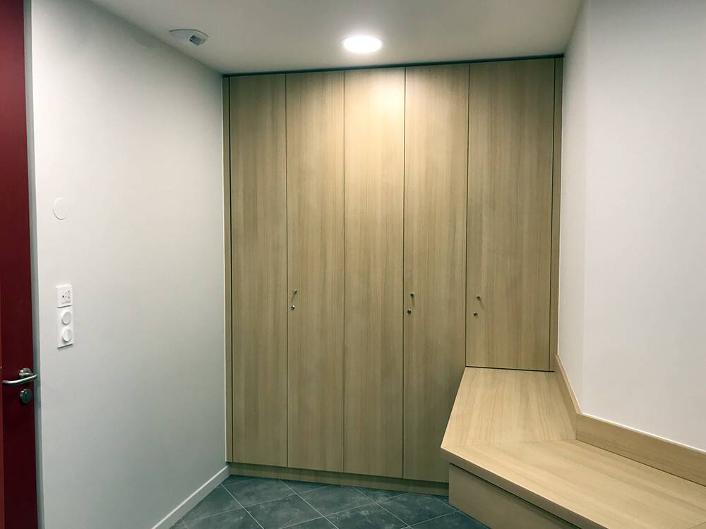 Vestiaire sur-mesure en bois clair avec banc intégré