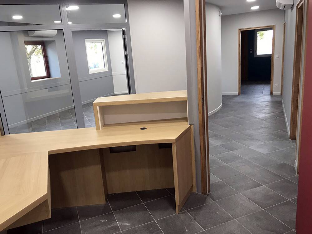 Banque d'accueil et bureau en bois clair dans bâtiment public
