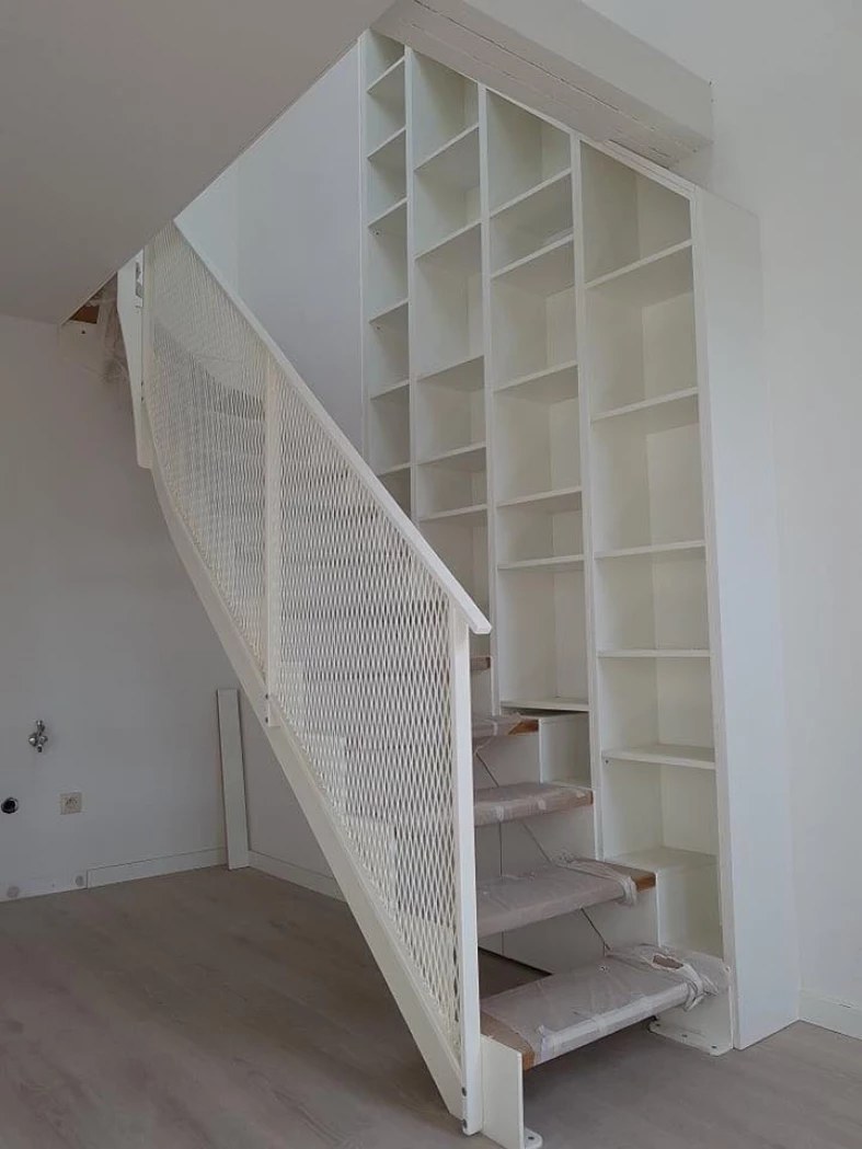 Escalier laqué blanc avec bibliothèque intégrée sous rampant