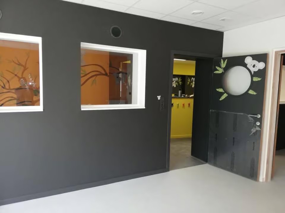 Couloir d'école avec porte décorée koala et fenêtres intérieures